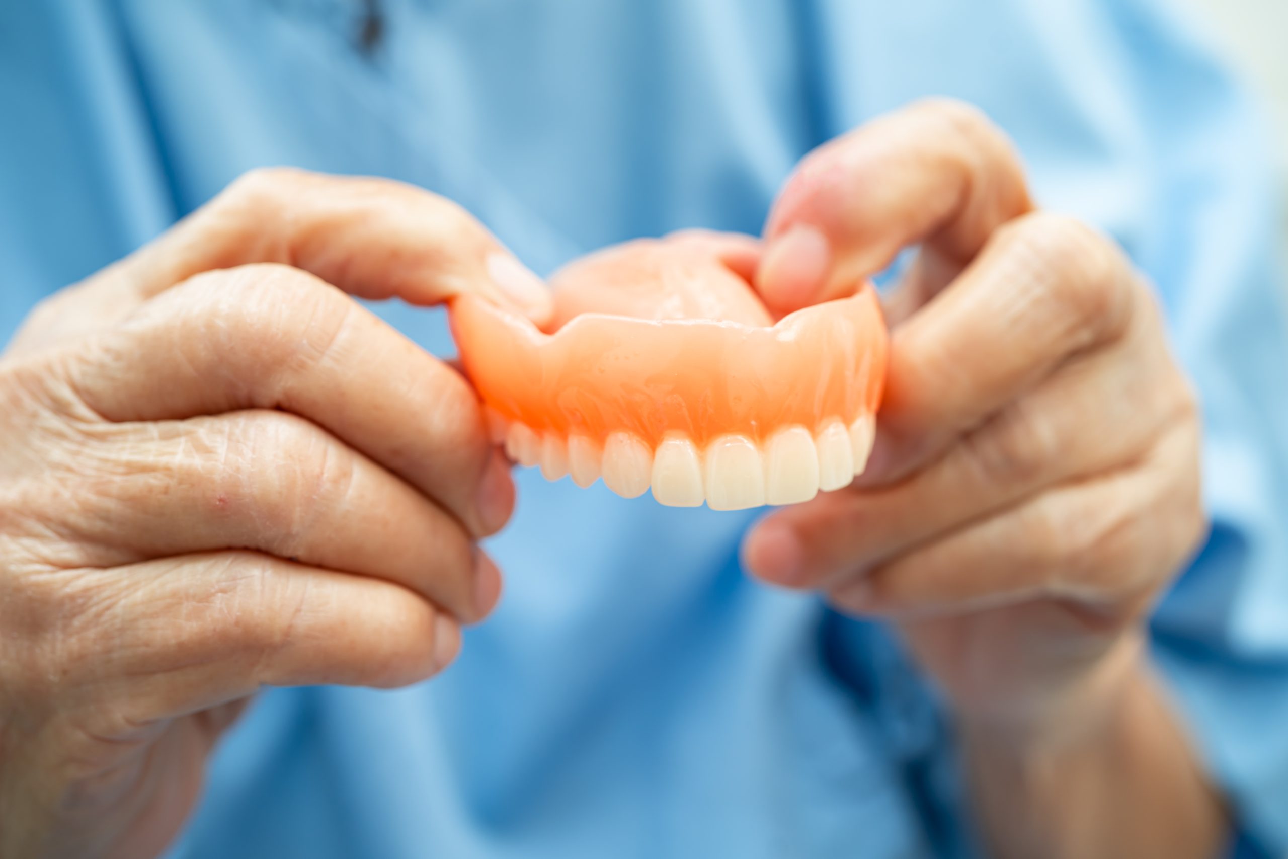 asian elderly woman patient holding to use denture, healthy stro